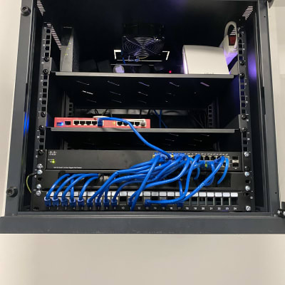 ארון תקשורת עם נתבים וכבלים כחולים מחוברים