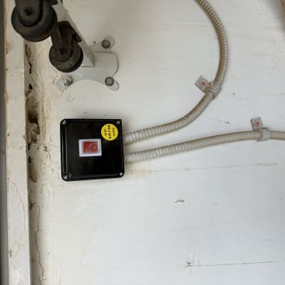 קופסת חשמל עם כפתור אדום וכבלים מחוברים