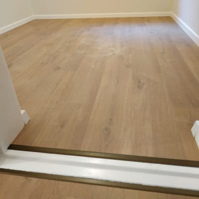 רצפת פרקט עץ בהירה עם מסגרת מתכת