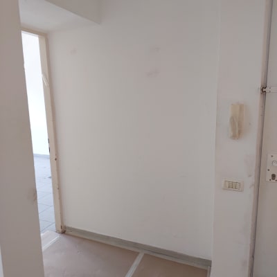 קיר צבוע בלבן עם רצפה מכוסה בנייר