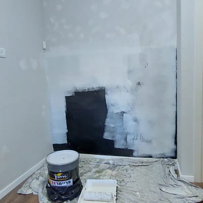 קיר צבוע חלקית עם גליל צבע ומגש על יריעה