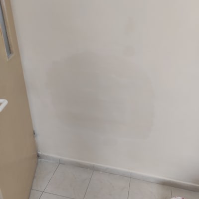 קיר צבוע חלקית עם דלי צבע על הרצפה