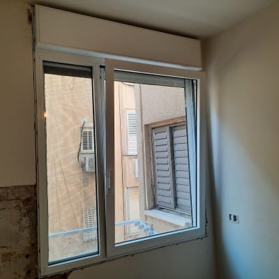 חלון אלומיניום פתוח עם מסגרת לבנה