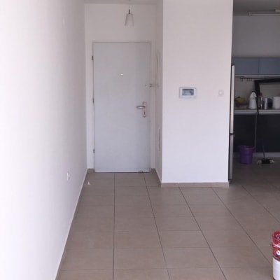 פחית צבע אדום על רצפה ליד קיר לבן