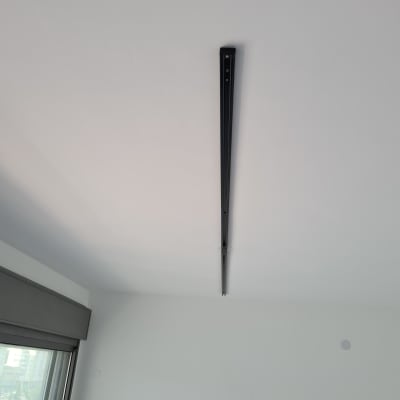 מסילת תאורה שחורה מותקנת על תקרה לבנה