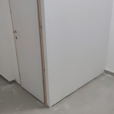 קיר גבס לבן עם דלת עץ צמודה