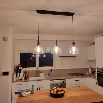 מנורות תלויות עם נורות דולקות מעל שולחן עץ