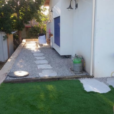 שביל אבנים בגינה עם דשא סינתטי