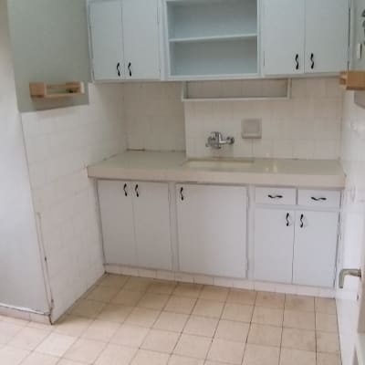 מטבח נקי עם ארונות לבנים וכיור