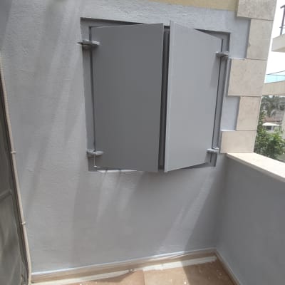 קיר צבוע באפור עם חלון מתכת פתוח