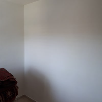 קיר לבן צבוע עם צל של מנורה