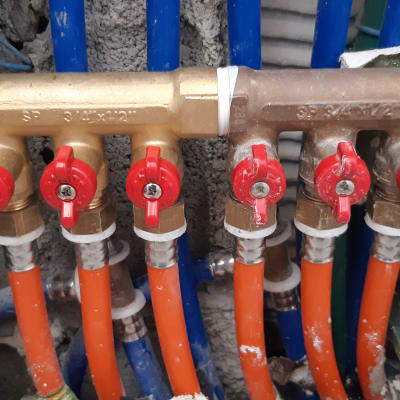ברזים אדומים על צינורות פלסטיק כחולים וכתומים