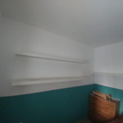 מדפים לבנים מותקנים על קיר לבן