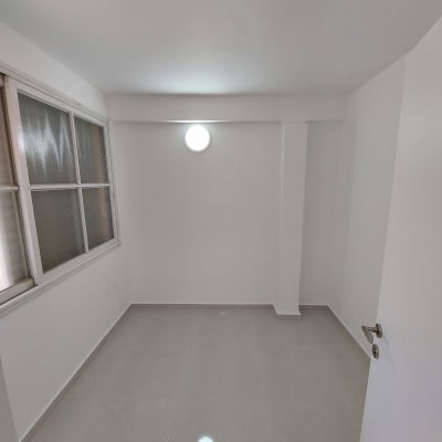 חדר משופץ עם קירות לבנים ורצפת קרמיקה חדשה