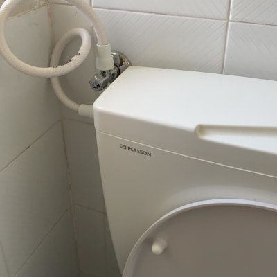 אסלה עם צינור מים מחובר לקיר