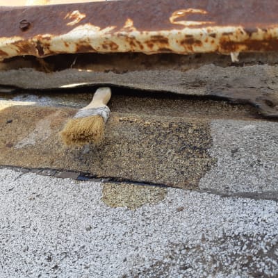 מברשת על גג עם חומר איטום