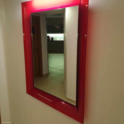 מראה עם מסגרת אדומה תלויה על קיר