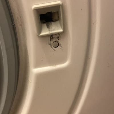 חלק ממכונת כביסה עם כפתור ולכלוך