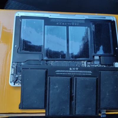 סוללת מחשב נייד פתוחה על משטח קרטון