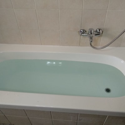 אמבטיה מלאה מים עם ברז וכיסוי קיר קרמיקה