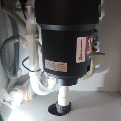 מטחנת אשפה מותקנת מתחת לכיור עם צינורות חיבור