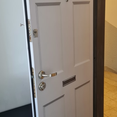 דלת אפורה עם ידית מתכת ובריחים