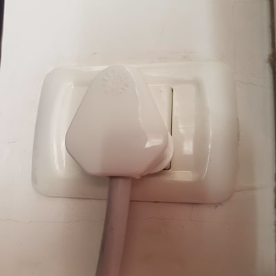 תקע חשמלי לבן בשקע קיר