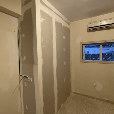 קיר גבס בתהליך שיפוץ עם חוטי חשמל חשופים