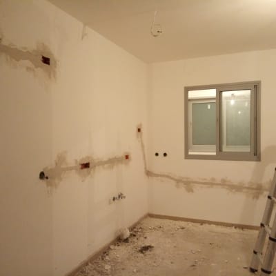 קירות עם חוטי חשמל חשופים וסולם בחדר