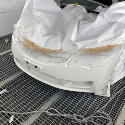 רכב מכוסה בניירות בתהליך צביעה במוסך