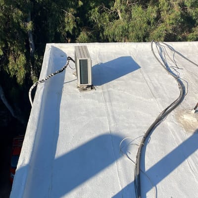 גג אטום עם ציפוי לבן וכבלים חשמליים