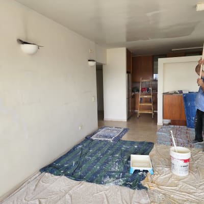 אדם צובע תקרה עם רולר בחדר