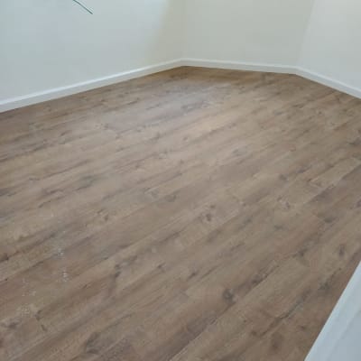 רצפת פרקט עץ בחדר עם קירות לבנים