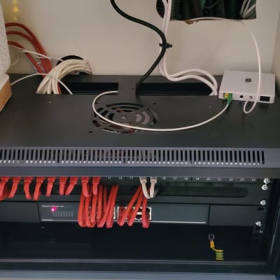 ארון תקשורת עם נתב, כבלים אדומים ומתג רשת