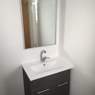 כיור עם ארון ומראה בחדר אמבטיה