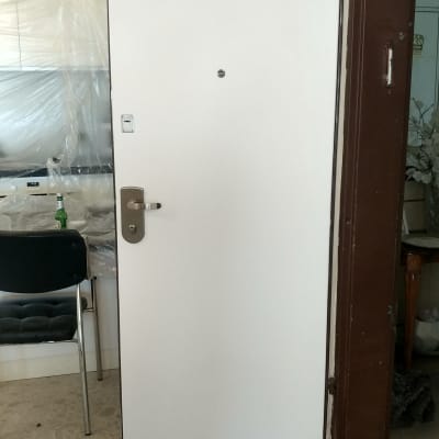 דלת לבנה עם ידית מתכת כסופה