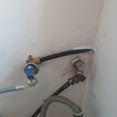 צינורות מים עם ברזים על קיר לבן