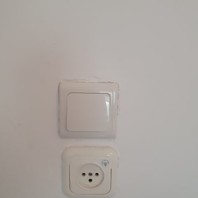 שקע חשמל ומתג על קיר לבן