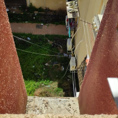 מזגנים מותקנים על קיר בניין עם כביסה תלויה