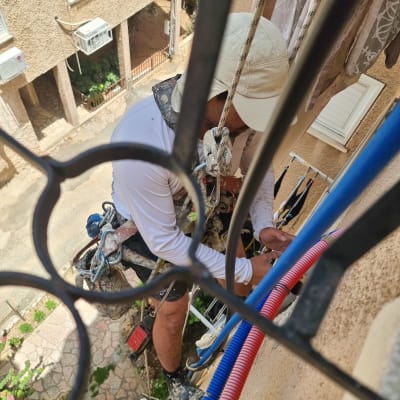 אדם עובד על צינורות מים בצבעים שונים