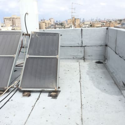 גג אטום עם יריעות ביטומניות ושני קולטי שמש