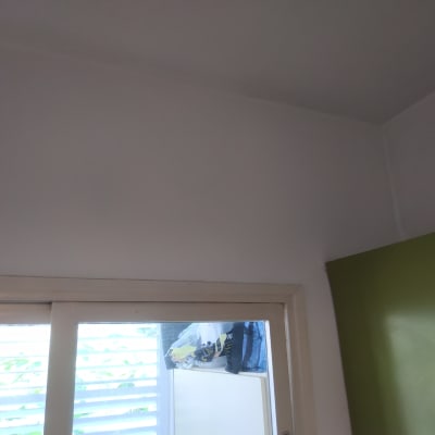 קיר צבוע בלבן ליד ארון ירוק