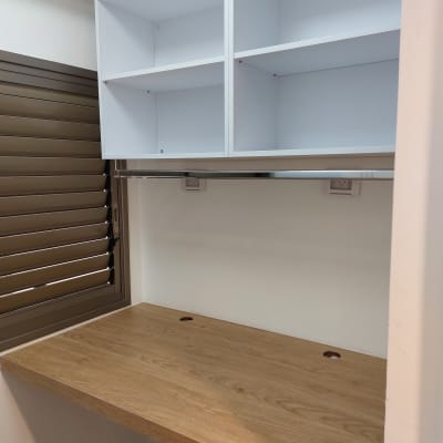 שולחן עץ עם מדפים לבנים מעליו