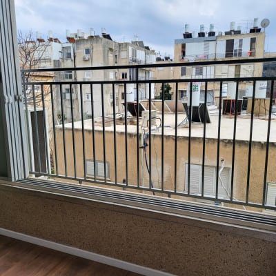 מסגרת חלון עם סורגים מתכתיים על רקע בניינים