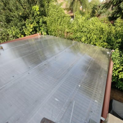 גג פלסטיק שקוף עם ברגים בגינה ירוקה