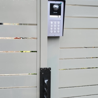 אינטרקום עם מקלדת על שער מתכת אפור