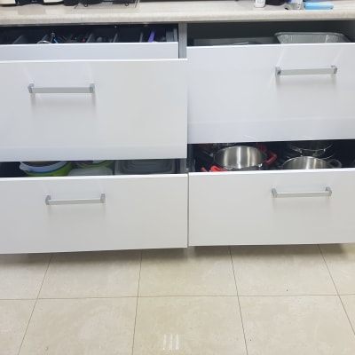 מגירות מטבח פתוחות עם סירים וכלי פלסטיק