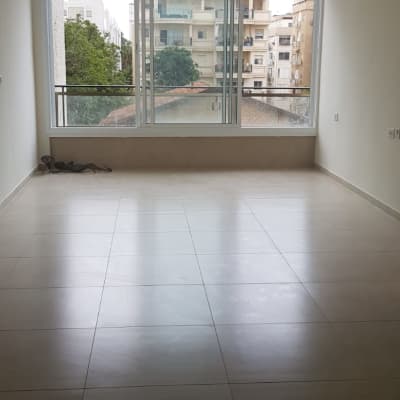 חדר ריק עם רצפת אריחים וחלון גדול