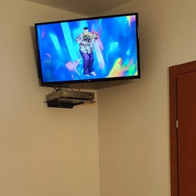 טלוויזיה מותקנת על הקיר עם ממיר מתחתיה