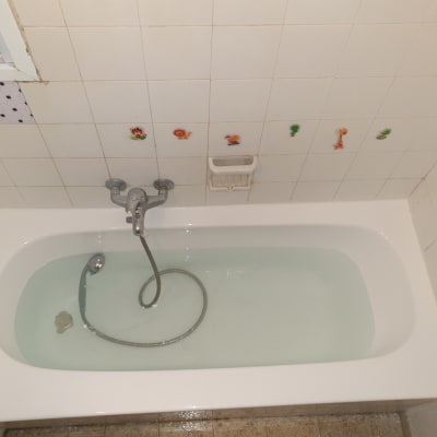 אמבטיה עם מים, ברז ומדבקות על הקיר